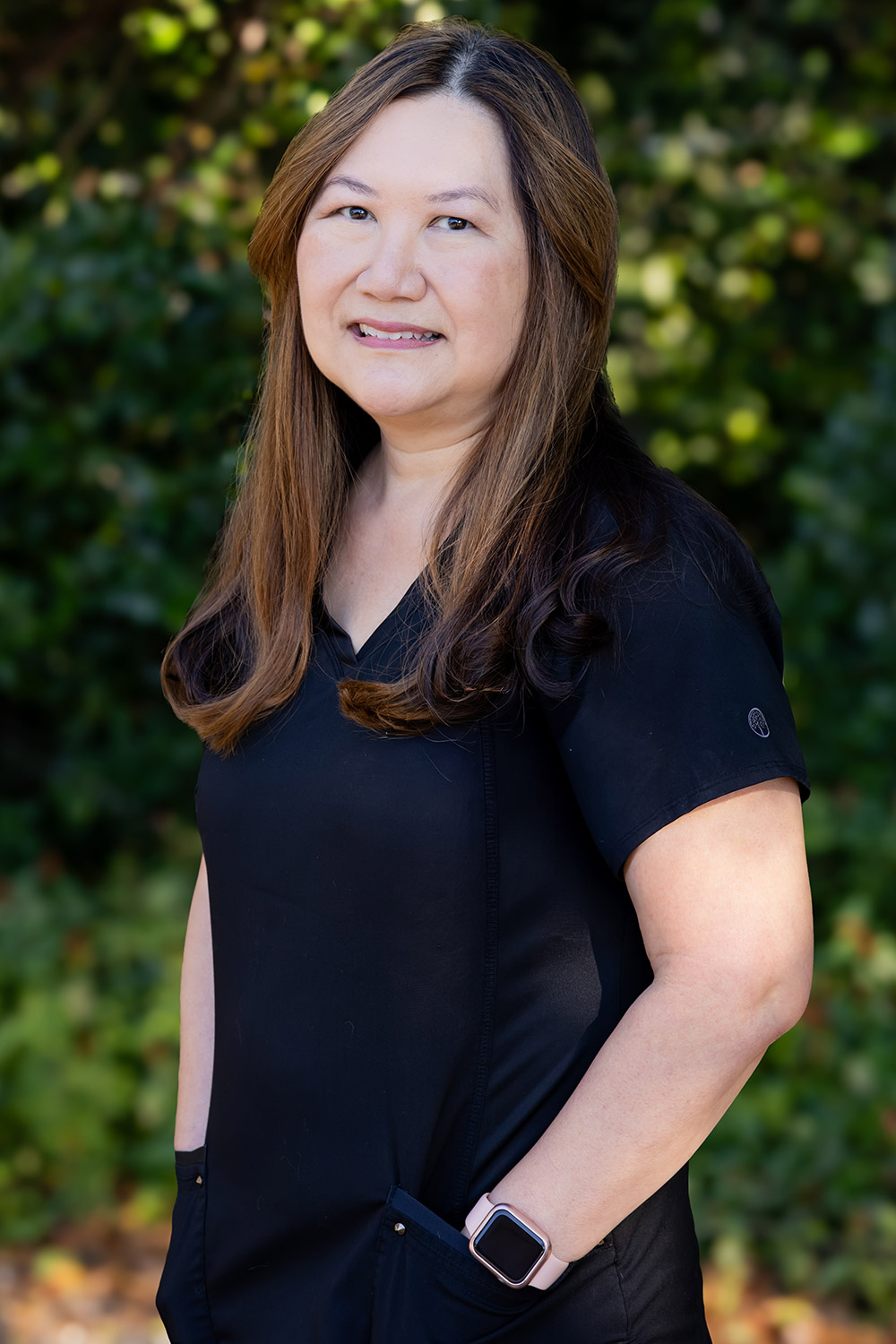 Lisa, Dental Hygienist at DeLand Family Dental, smiling outdoors in black scrubs.