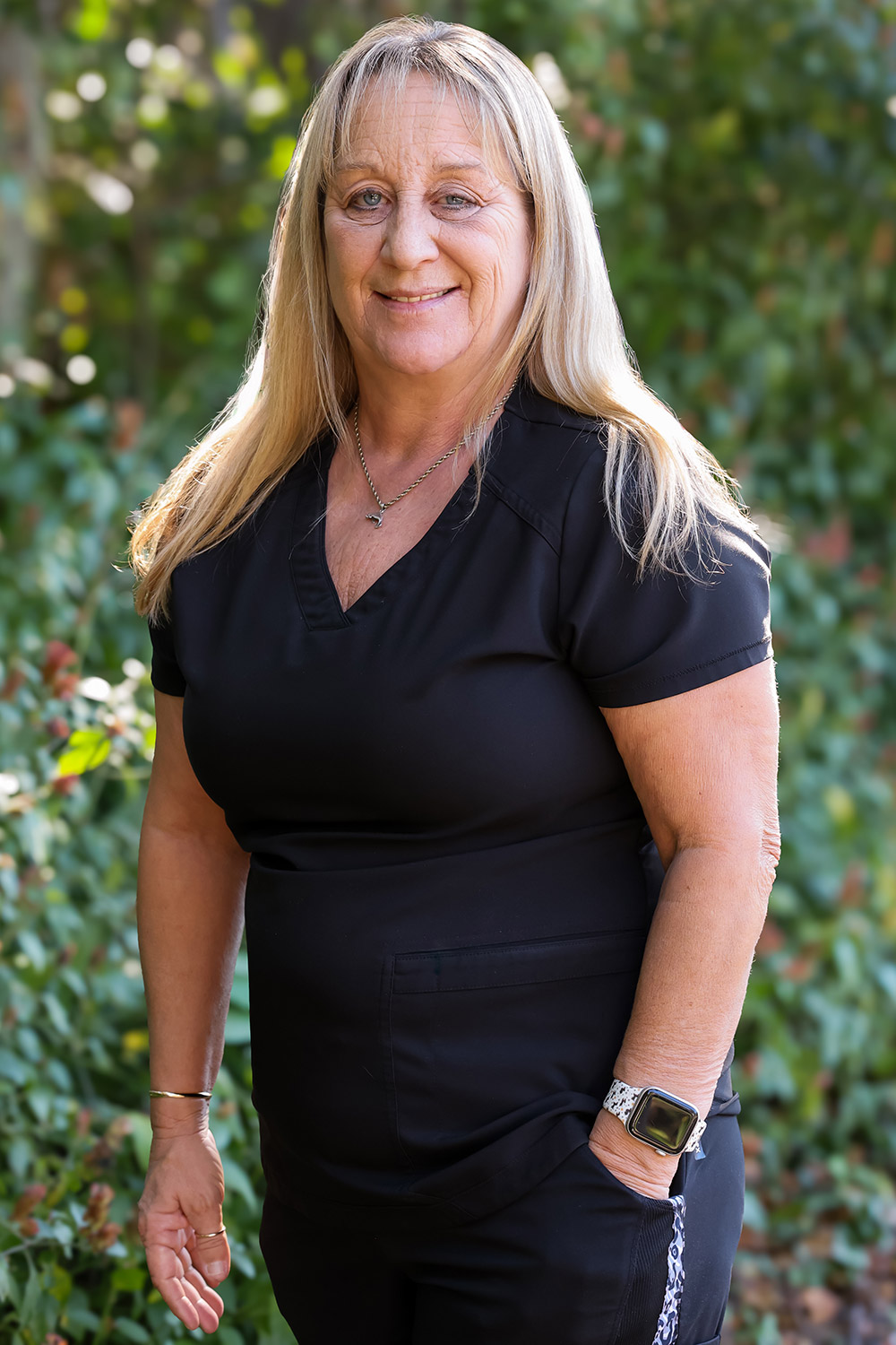 Tracy, Dental Hygienist at DeLand Family Dental, smiling outdoors in black scrubs.